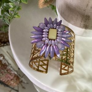 Gold toned adjustable cuff bracelet with purple stone flower